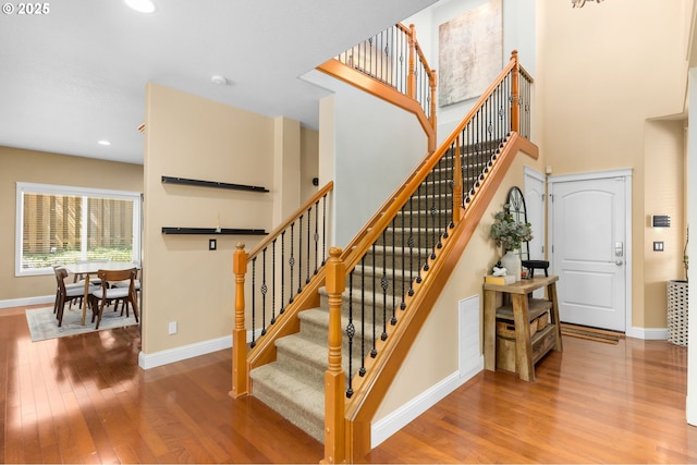 15655 SW Greenfield Dr, Portland, OR 97224 - stairway with wood finished floors, a towering ceiling, and recessed lighting
