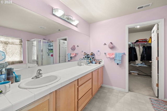 2032 SW 33rd St, Gresham, OR 97080 - bathroom with double vanity, a stall shower, baseboards, a walk in closet, and tile patterned floors