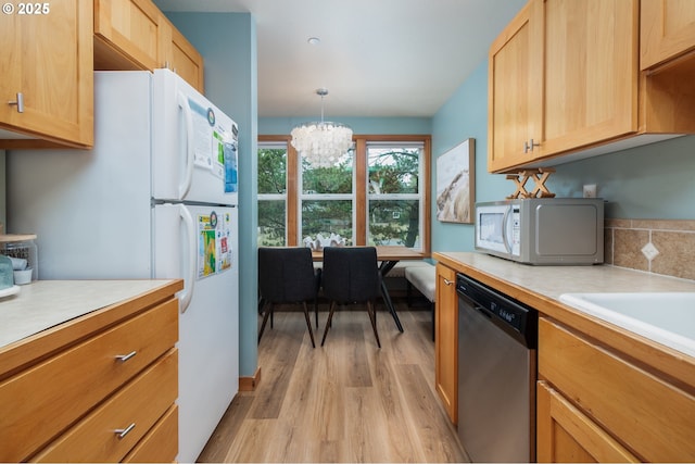 5904 Barefoot Ln, Pacific City, OR 97135 - kitchen with white appliances, light countertops, light wood-type flooring, a chandelier, and pendant lighting