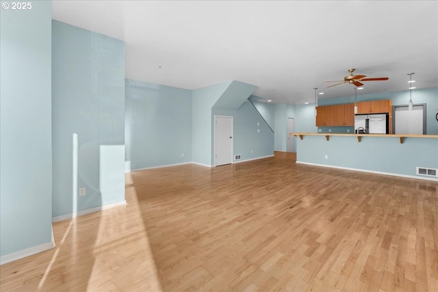 unfurnished living room with ceiling fan and light hardwood / wood-style flooring