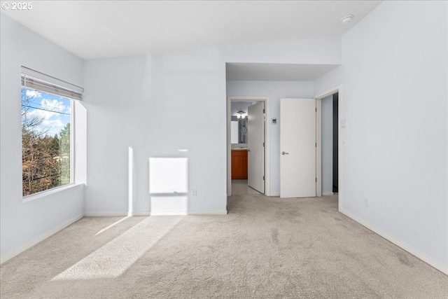 carpeted empty room featuring vaulted ceiling