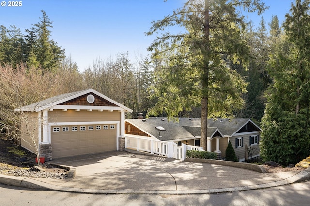 view of front of home with concrete driveway, a garage, and stone siding