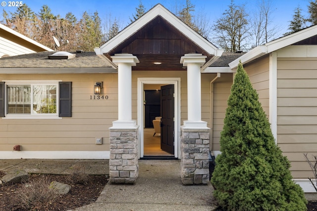 entrance to property with roof with shingles