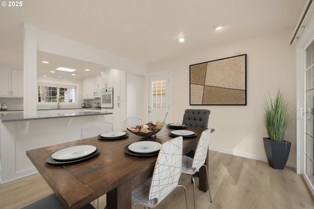 dining room with recessed lighting, light wood-type flooring, and baseboards