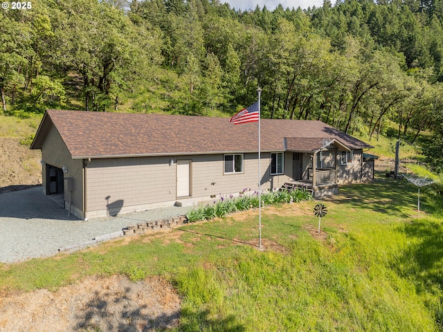 460 Huckleberry Mt Ln, Riddle, OR 97469 - view of front facade featuring a wooded view, a shingled roof, a garage, and a front yard