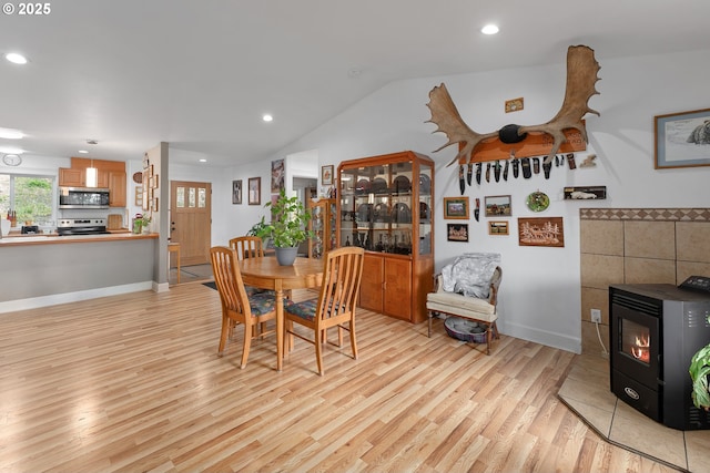 460 Huckleberry Mt Ln, Riddle, OR 97469 - dining space featuring light wood-type flooring, a wood stove, recessed lighting, lofted ceiling, and baseboards
