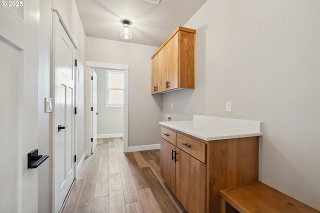 clothes washing area featuring cabinets, washer hookup, and light wood-type flooring