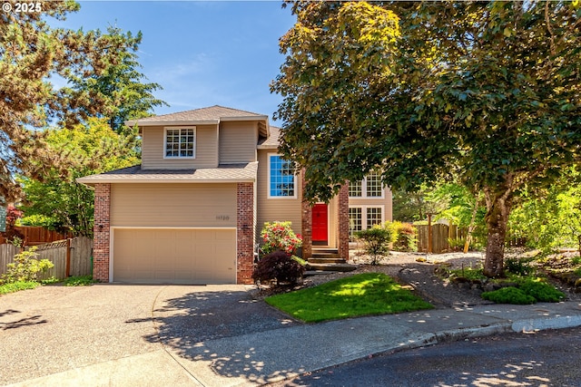 view of front of house with brick siding, driveway, a garage, and fence