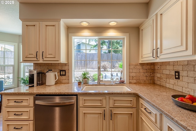 kitchen with backsplash, a healthy amount of sunlight, dishwasher, and a sink