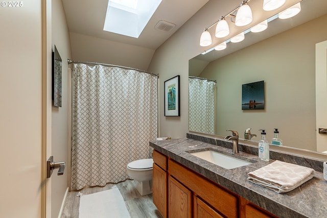 full bathroom featuring visible vents, toilet, wood finished floors, a skylight, and vanity