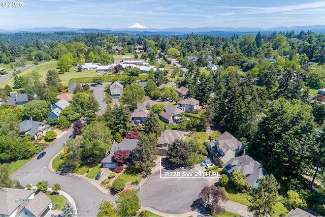 drone / aerial view featuring a forest view, a mountain view, and a residential view