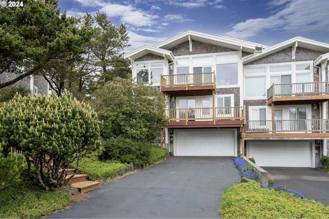 view of front of home featuring driveway, stone siding, and a garage