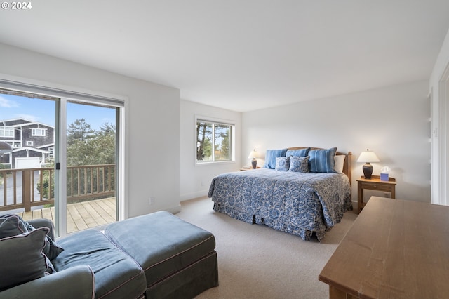 carpeted bedroom featuring baseboards and access to outside