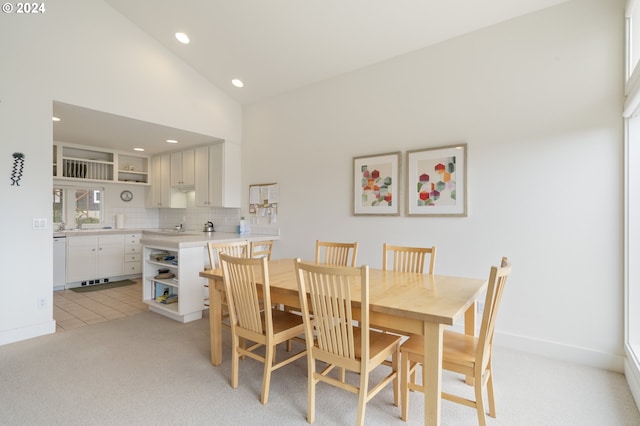 dining space featuring light tile patterned flooring, baseboards, high vaulted ceiling, recessed lighting, and light colored carpet