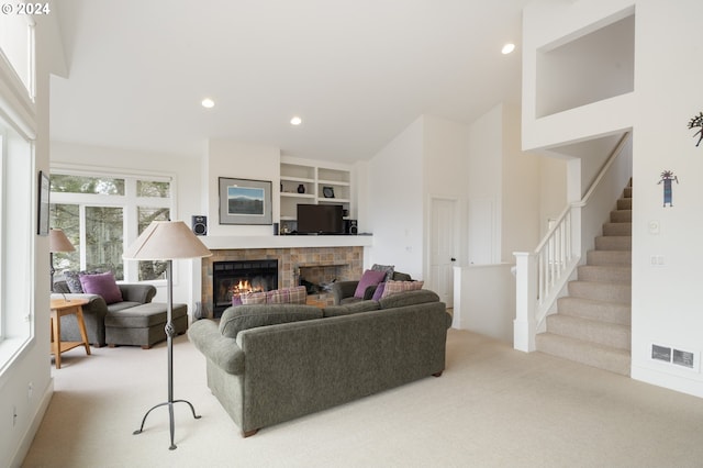 living room featuring stairs, a glass covered fireplace, high vaulted ceiling, recessed lighting, and carpet flooring