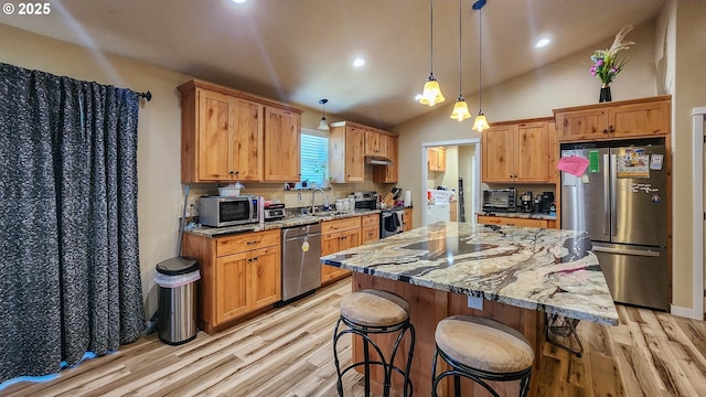 5135 Grange Rd, Roseburg, OR 97471 - kitchen with stainless steel appliances, a sink, light wood-style floors, under cabinet range hood, and light stone counters