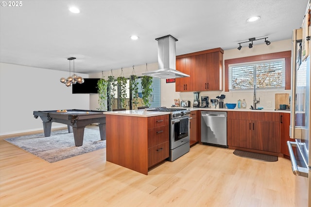 kitchen featuring island exhaust hood, stainless steel appliances, light hardwood / wood-style floors, and hanging light fixtures