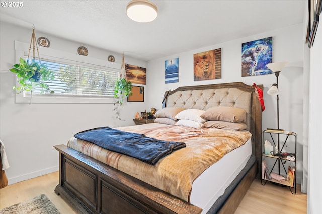 bedroom featuring light hardwood / wood-style floors and a textured ceiling