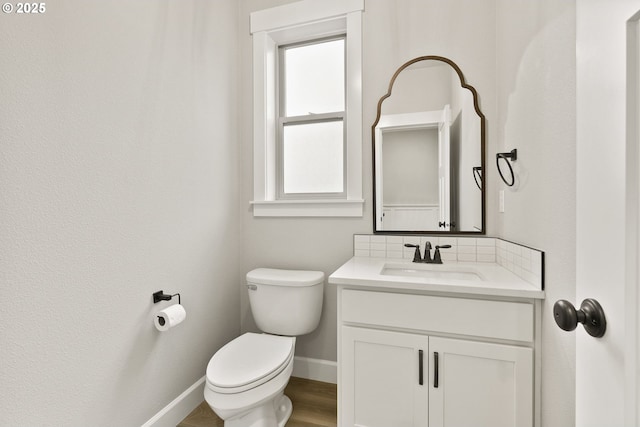 bathroom with baseboards, vanity, toilet, and wood finished floors