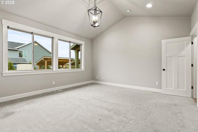 carpeted spare room featuring vaulted ceiling, a wealth of natural light, and baseboards