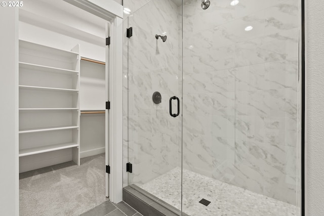 bathroom featuring a stall shower and a spacious closet