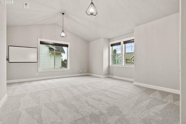 unfurnished room with baseboards, visible vents, vaulted ceiling, and light colored carpet