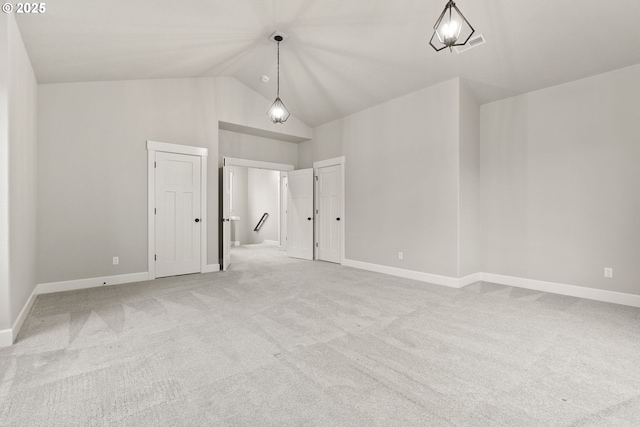 spare room with light carpet, high vaulted ceiling, and baseboards