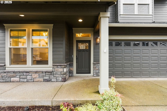 doorway to property featuring stone siding and concrete driveway