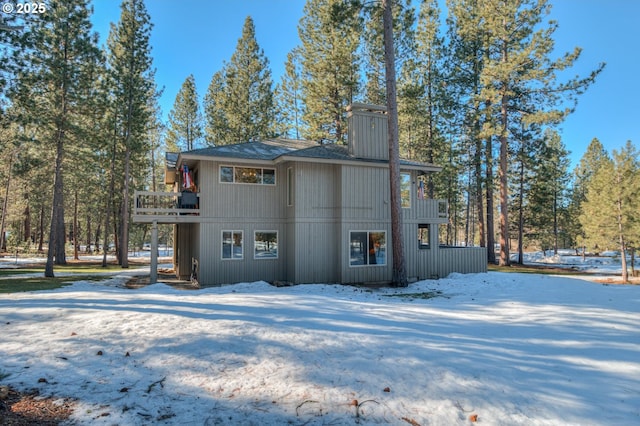 back of property with a balcony and a chimney