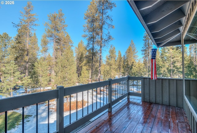 wooden deck with a wooded view