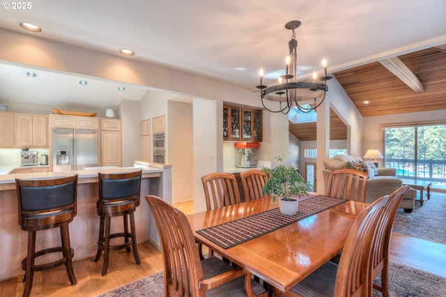 dining room featuring vaulted ceiling with beams, light wood-style floors, recessed lighting, and a chandelier