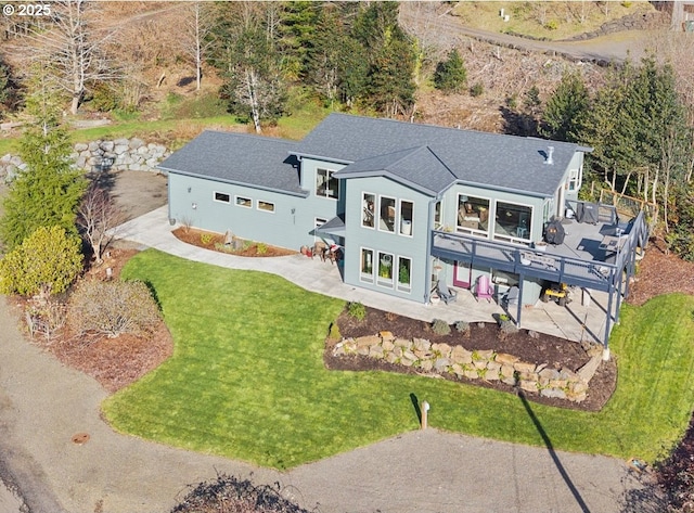 9065 8th St, Bay City, OR 97107 - back of property featuring a patio, a wooden deck, a lawn, and a shingled roof