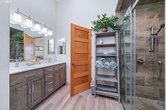 9065 8th St, Bay City, OR 97107 - full bathroom with double vanity, a stall shower, and wood finished floors