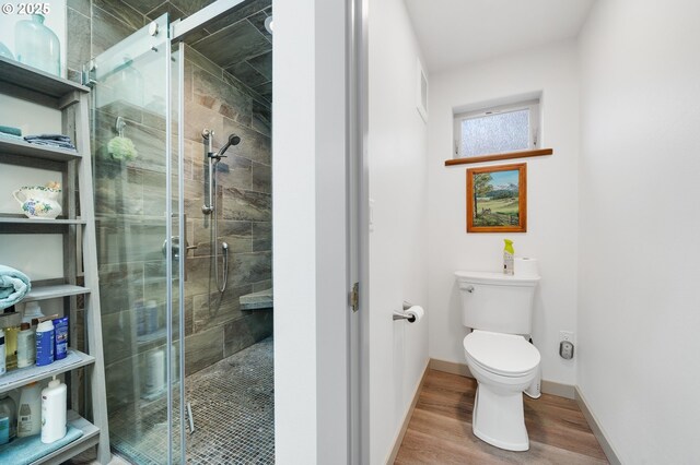 9065 8th St, Bay City, OR 97107 - bathroom with toilet, a shower stall, wood finished floors, and baseboards