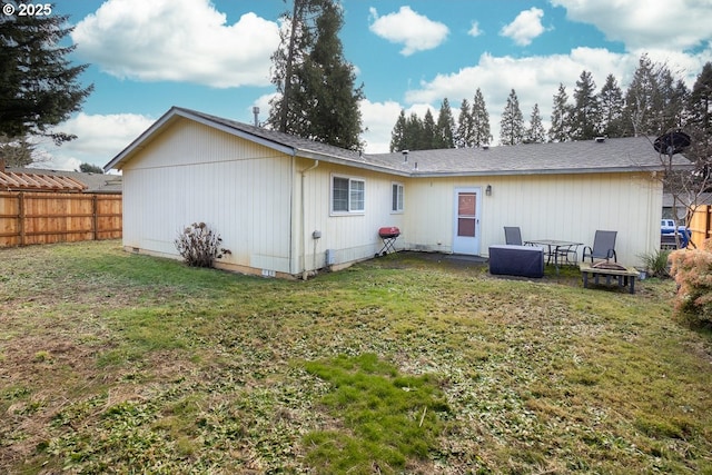 rear view of house featuring a yard and a fire pit