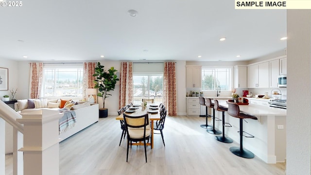 dining area featuring light wood finished floors, recessed lighting, and baseboards