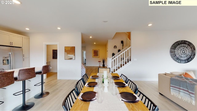 dining space featuring light wood-style flooring, stairs, recessed lighting, and baseboards