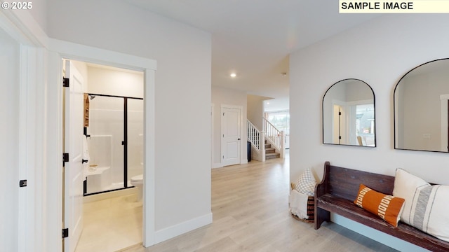 corridor featuring light wood-style flooring, stairs, baseboards, and recessed lighting