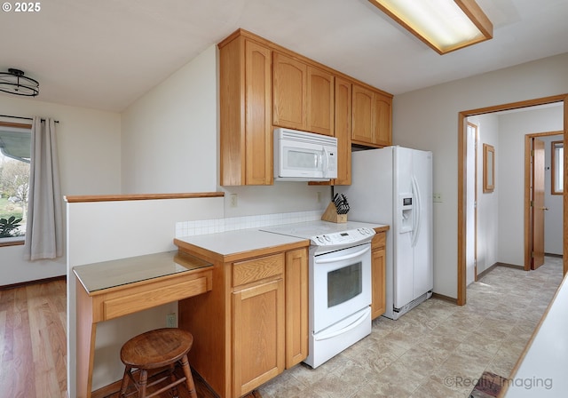 kitchen with baseboards, white appliances, light floors, and light countertops