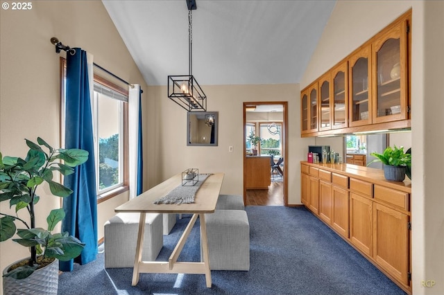 dining space with lofted ceiling and dark carpet