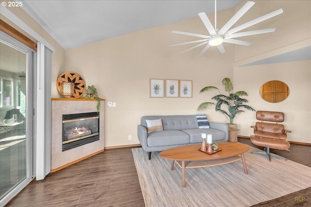 living room with lofted ceiling, a fireplace, wood finished floors, and baseboards