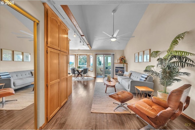 living room with high vaulted ceiling, a glass covered fireplace, ceiling fan, and wood finished floors