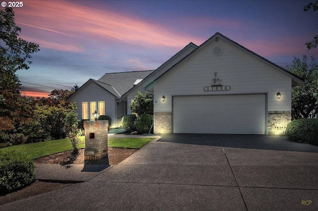 ranch-style home with a garage, concrete driveway, and brick siding