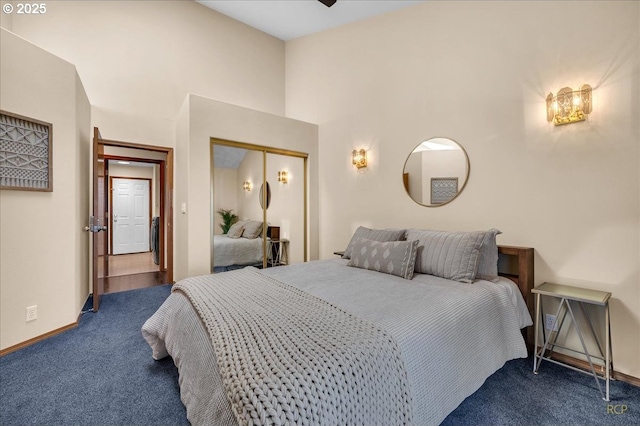 carpeted bedroom featuring a towering ceiling, baseboards, and a closet