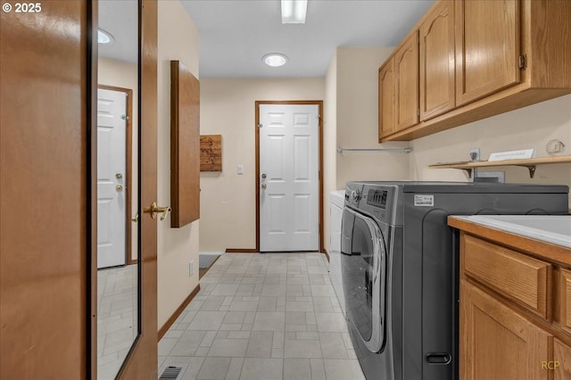 washroom with cabinet space, visible vents, baseboards, and separate washer and dryer