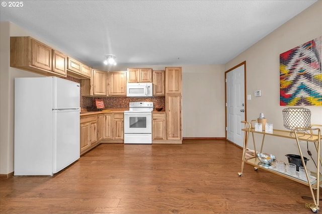 kitchen featuring tasteful backsplash, light brown cabinets, a textured ceiling, wood finished floors, and white appliances