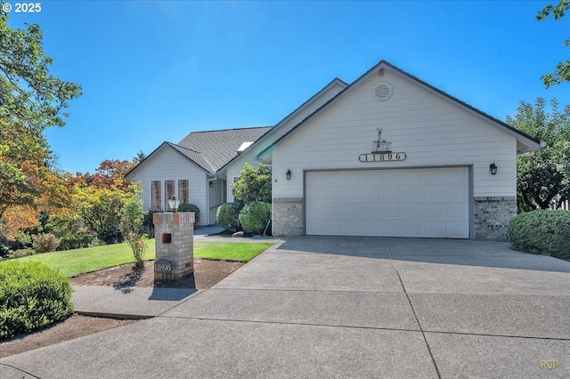 view of front of home featuring a front lawn, concrete driveway, brick siding, and an attached garage