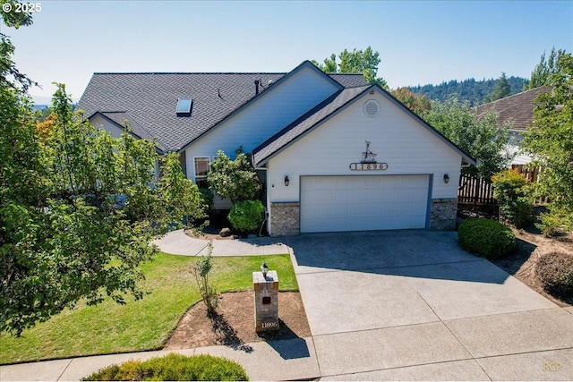 view of front of home featuring a front lawn, concrete driveway, and an attached garage