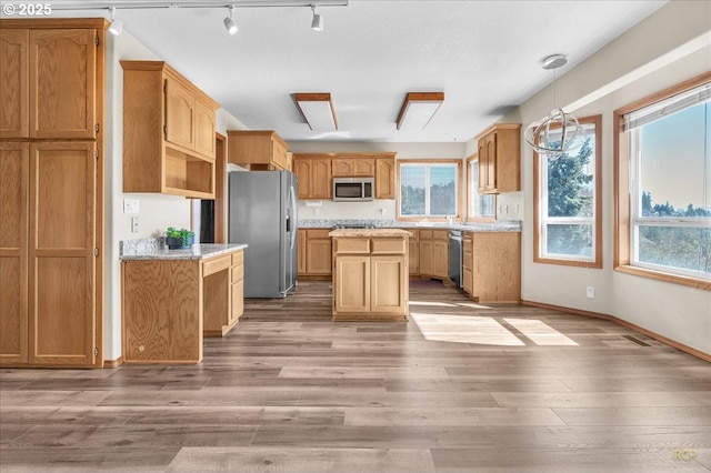 kitchen with stainless steel appliances, plenty of natural light, and wood finished floors