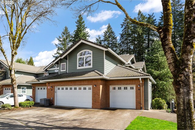 30406 SW Ruth St Unit 78, Wilsonville, OR 97070 - traditional home with concrete driveway, brick siding, an attached garage, cooling unit, and a tile roof
